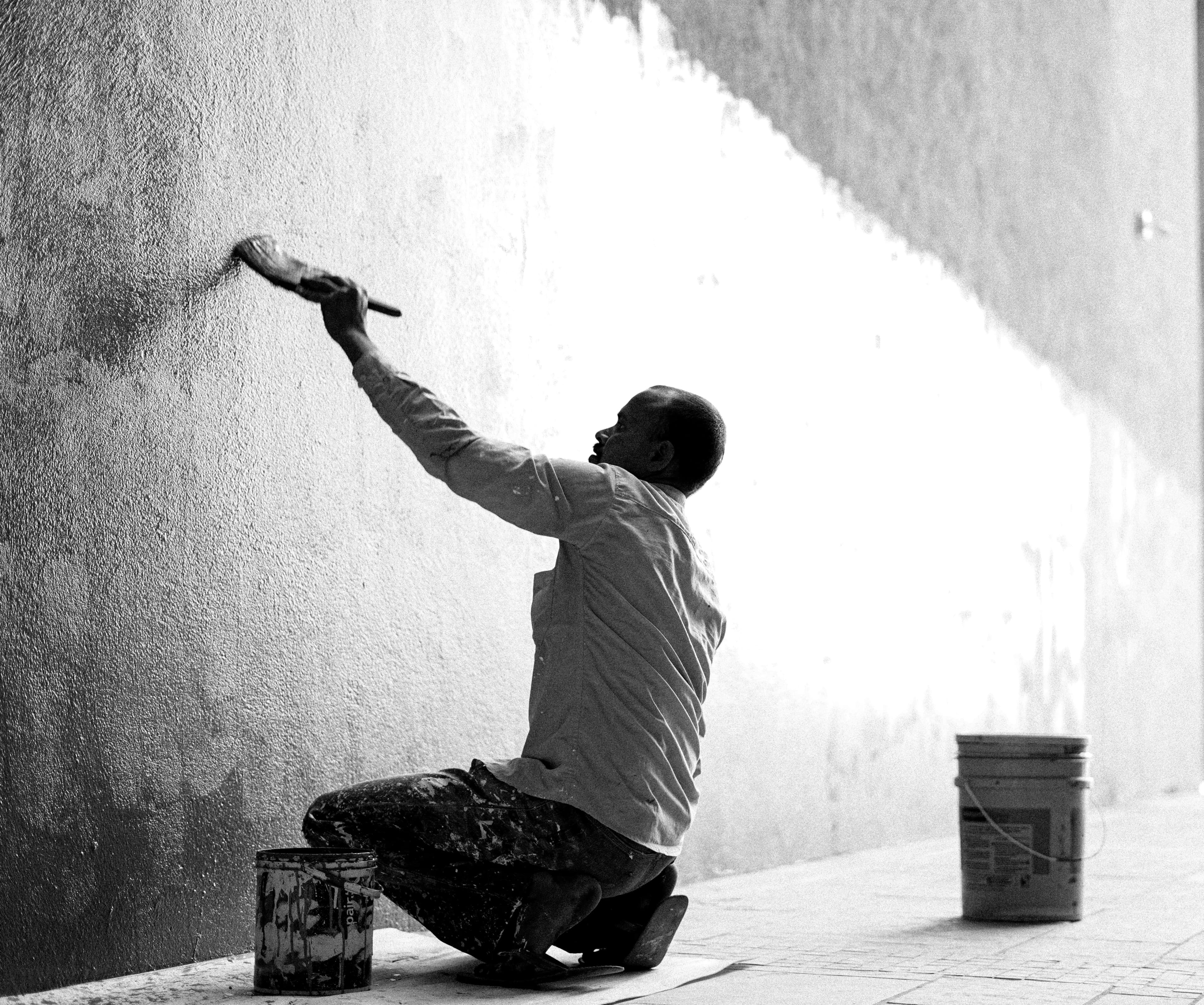 Peintre en train d'appliquer une peinture intérieure dans un appartement rénové avec finition soignée